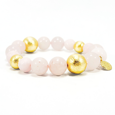 Bracelet with pink and gold beads on a white background