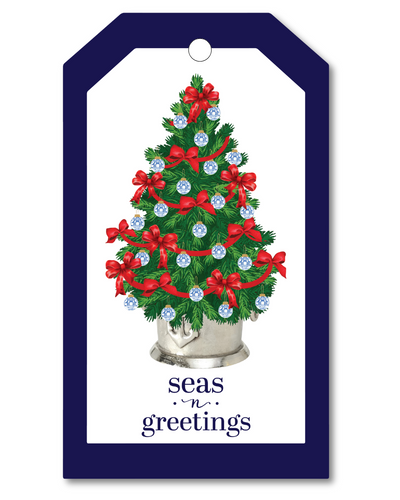 Christmas tree ornament with red bows and blue ornaments on a gift tag with 'seas n greetings' text.