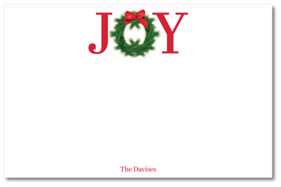 Christmas card with 'JOY' text featuring a wreath and bow on a white background